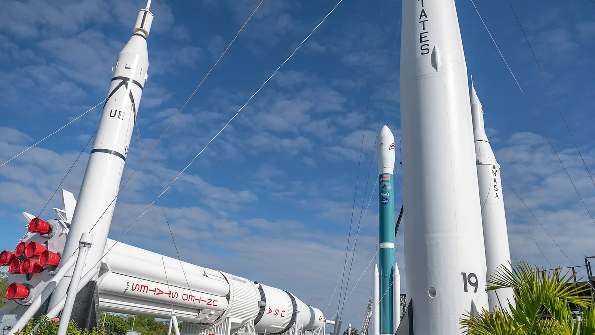 White rockets stand against a blue sky with clouds in a space garden display.