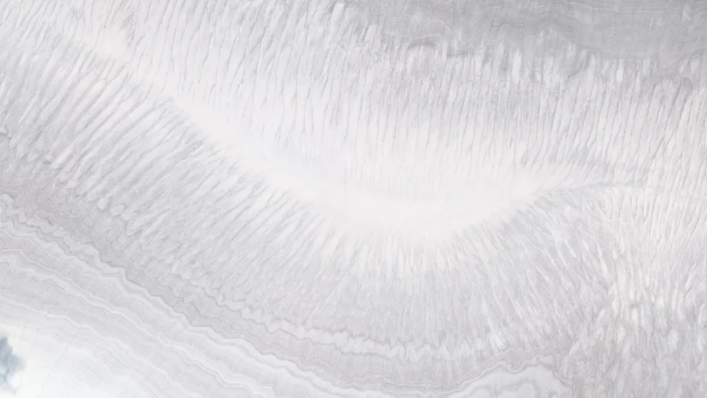 Detailed close-up of white ice cap layers showing intricate flow lines and subtle grey bandings.