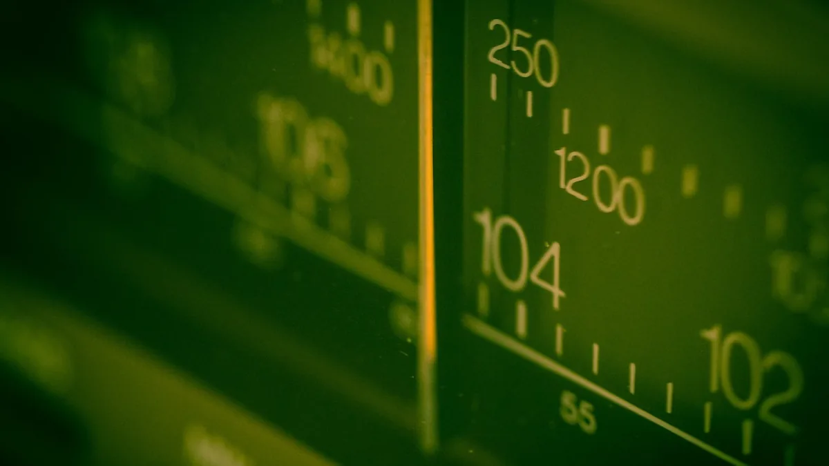 Green-tinted close-up of radio frequency dials showing numbers like 104, 102, and 1200, symbolizing spectrum.