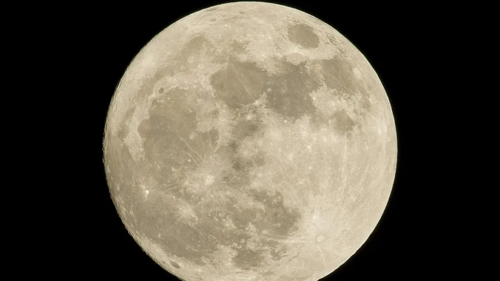 High-detail view of a luminous full moon showcasing craters and maria against a black sky.