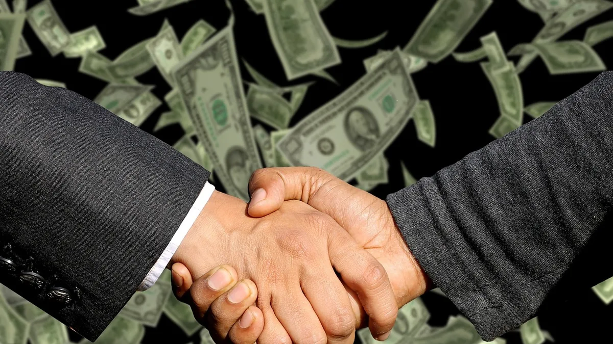 A business handshake with dollar bills falling in the background, symbolizing a lucrative partnership contract.