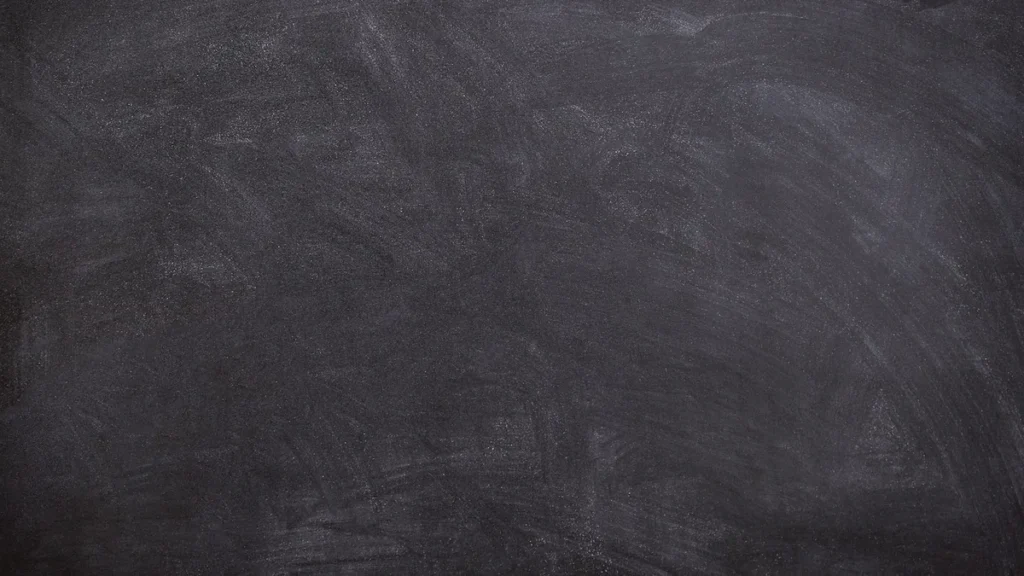 A dark, textured chalkboard surface with faint white smudges.