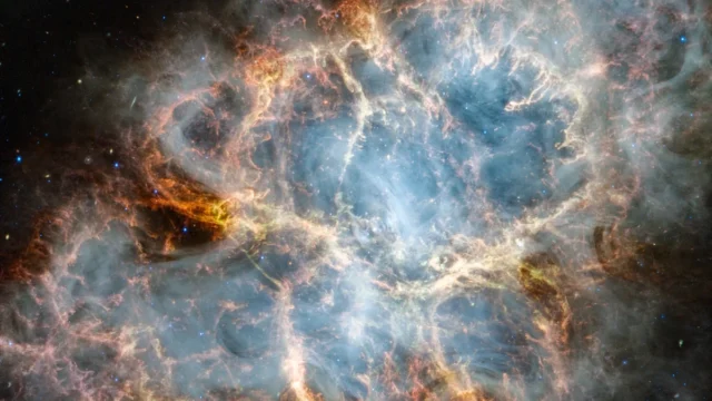 Vibrant cosmic nebula with intricate orange filaments surrounding a glowing blue core, dotted with distant stars.