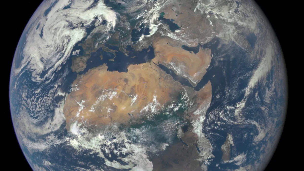 View of Earth from space showing Africa, Europe, the Middle East, and swirling white clouds over blue oceans.