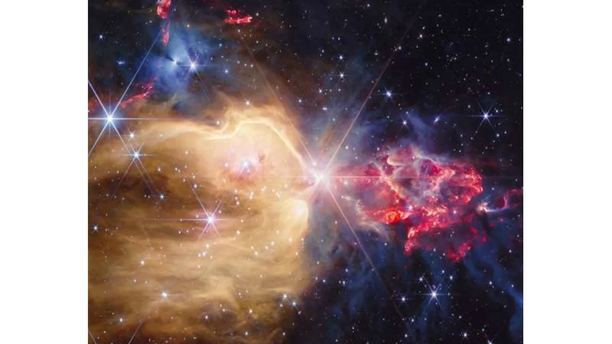 Vibrant nebula with golden dust on the left and clumpy red protostellar gas on the right, dotted with bright stars.