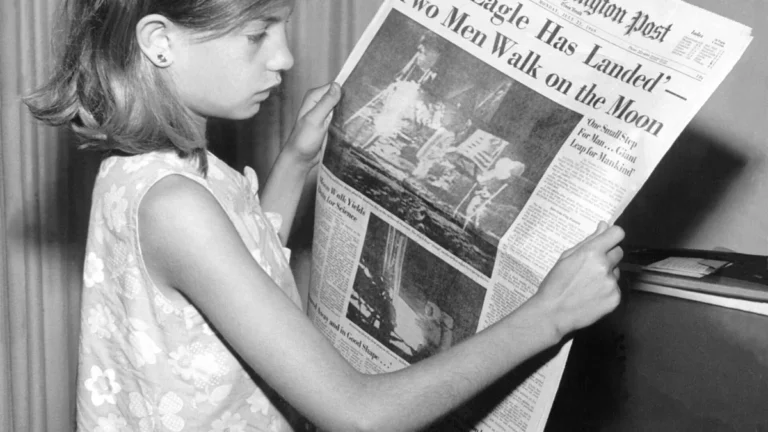 A young girl reads a 1969 newspaper announcing the historic first Moon landing by Apollo 11.