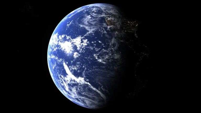 Earth in space, partially illuminated with clouds, oceans, and glowing city lights on the dark side.
