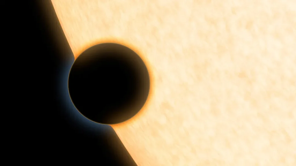 Artist's concept of a dark planet transiting a bright star with a glowing atmosphere.