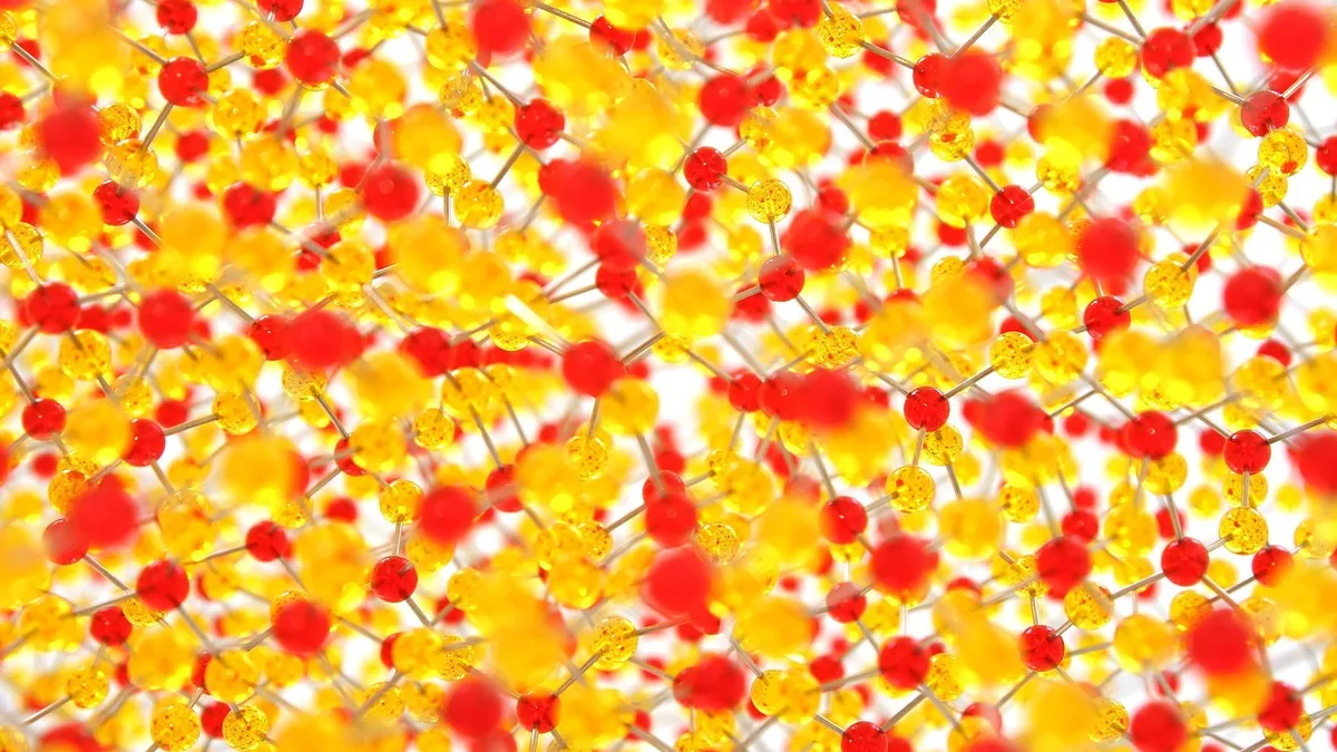 Abstract colorful network of red and yellow molecular spheres connected by bonds on a white background.