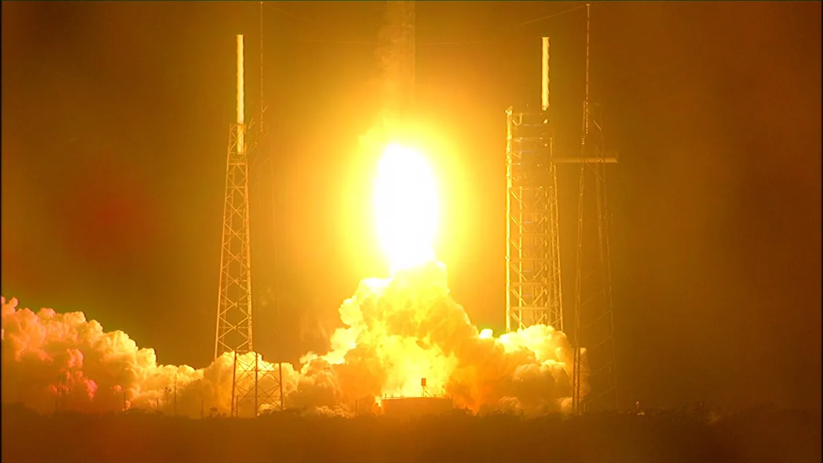 SpaceX Falcon 9 rocket launch with bright flames ascending from launchpad during nighttime