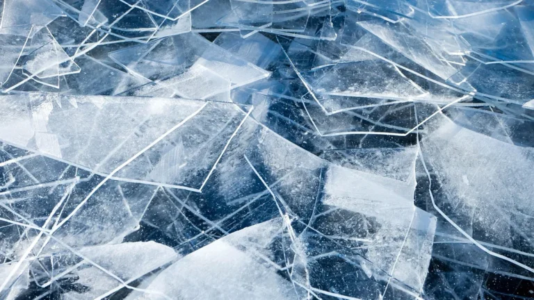 Sharp, overlapping shards of translucent blue ice with intricate cracks and frozen textures.