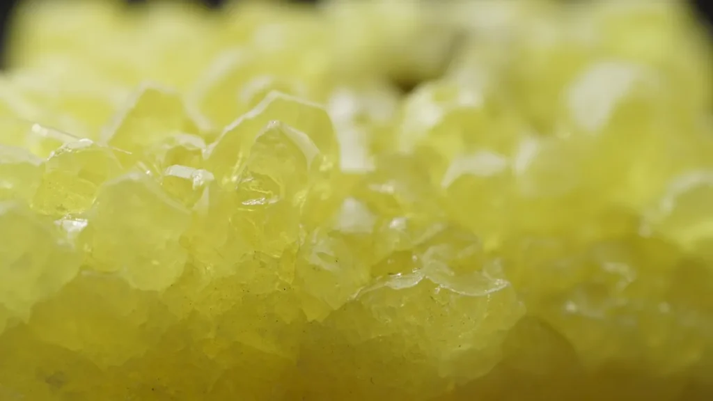 Yellowish translucent crystals, likely halite, captured in macro close-up with shallow depth of field.