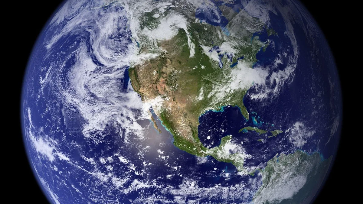 View of Earth from space showing North America, swirling clouds, and deep blue oceans against black space.