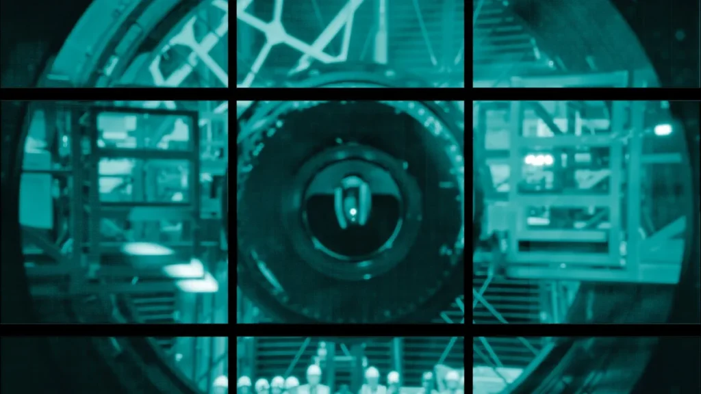 Green-tinted grid view of a circular telescope lens with workers in hard hats.