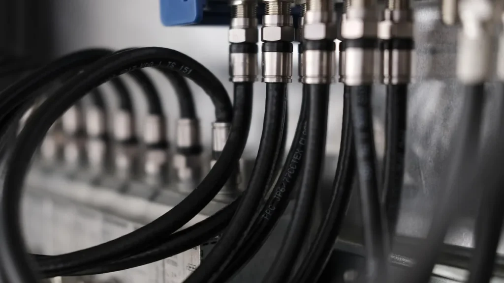 Close-up of black coaxial cables with metallic connectors showing technical cabling infrastructure.