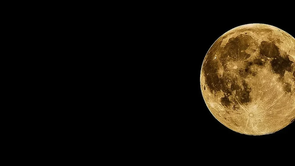 A golden full moon against a pitch-black sky, positioned on the right side of the frame.