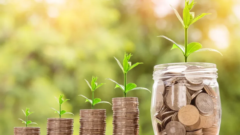 Green plants growing from stacks of coins and a jar, symbolizing financial growth and prosperity.