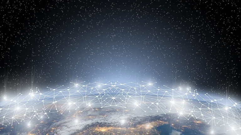 A glowing white network of interconnected satellite nodes orbiting a city-lit Earth against a starry sky.