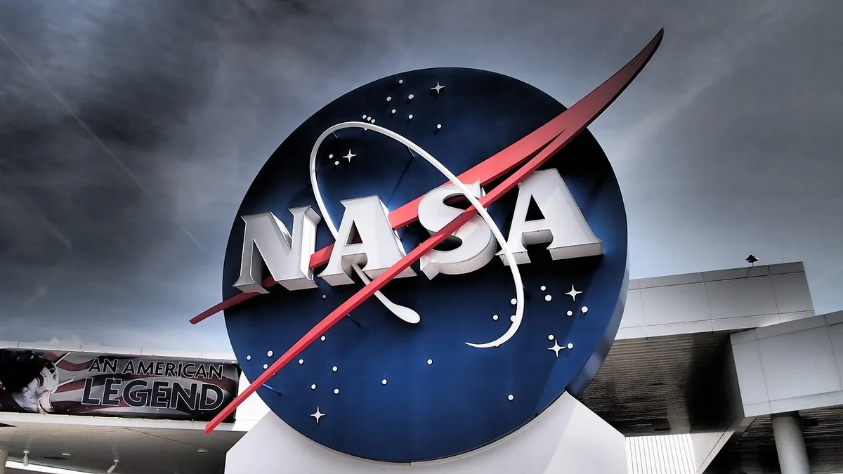 Large NASA logo set against a cloudy sky with a banner reading 'An American Legend' in the lower left.