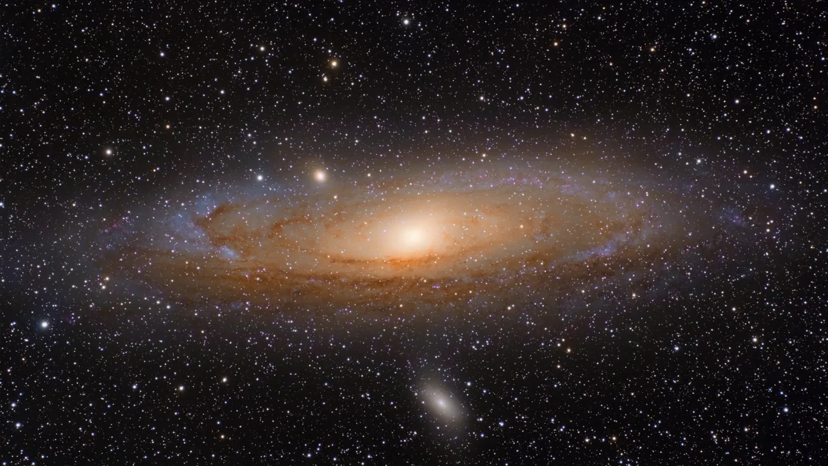 The Andromeda Galaxy, a bright spiral galaxy surrounded by stars and a small companion galaxy.