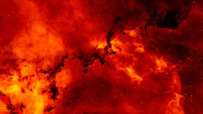 A vibrant red and orange nebula filled with stars and dark cosmic dust lanes.