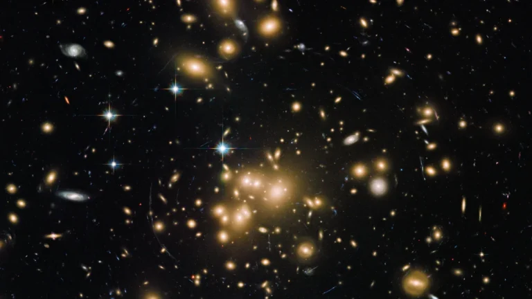 Golden galaxy cluster MACS J0454.1-0300 glows with bright stars and distant galaxies in deep space.
